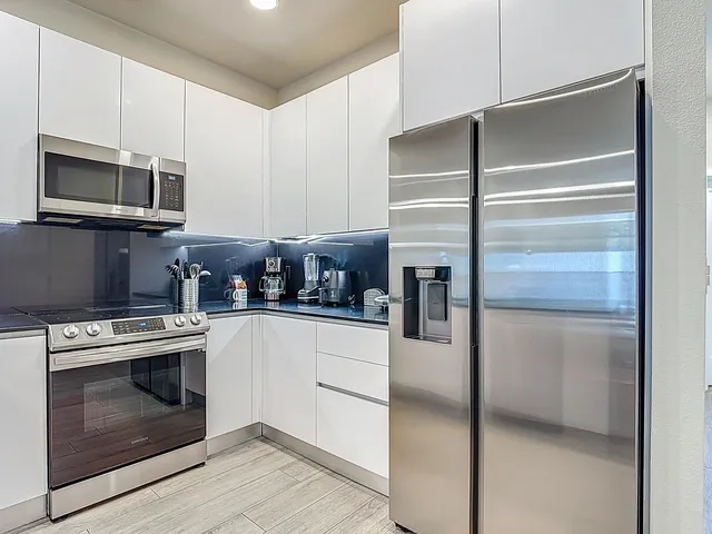 a living room with furniture kitchen and a chandelier