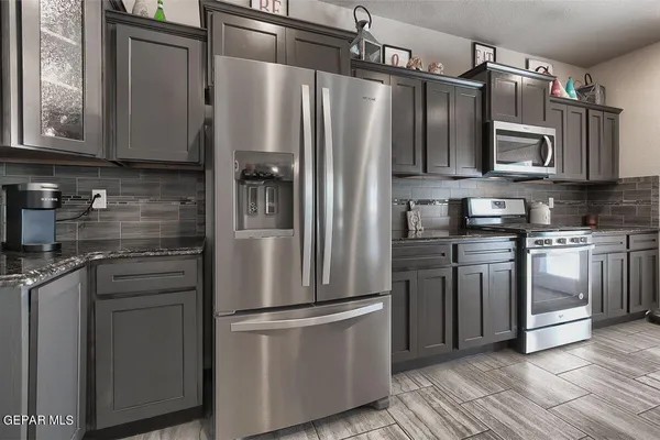 a kitchen with stainless steel appliances granite countertop a sink stove and refrigerator