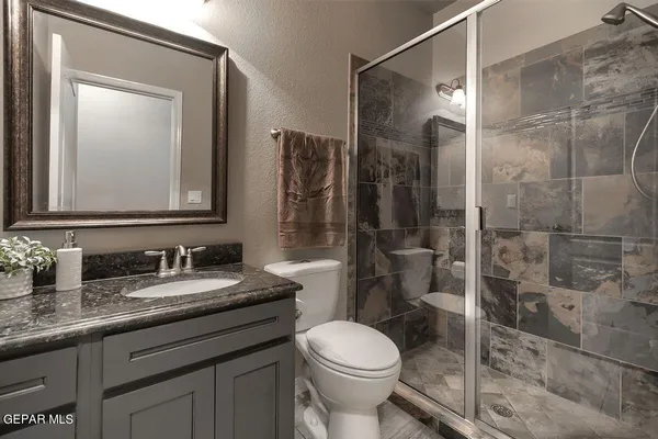 a bathroom with a granite countertop sink and a mirror