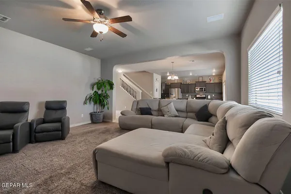 a kitchen with stainless steel appliances granite countertop table chairs and a chandelier