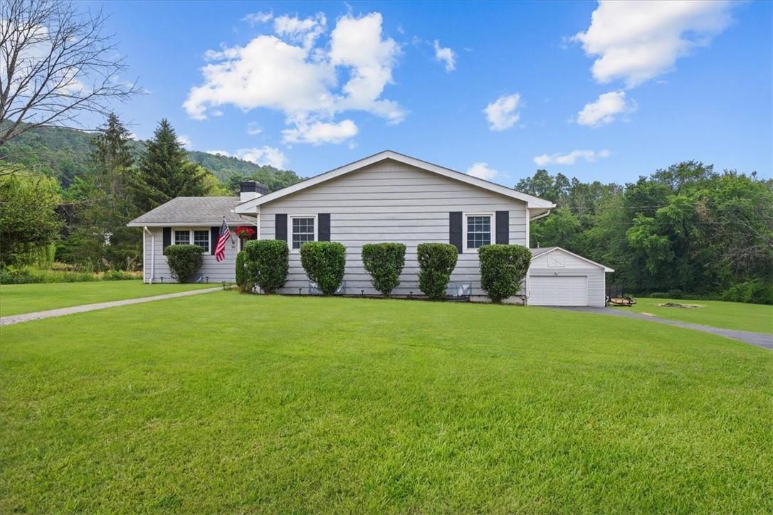 a view of house with outdoor space and garden