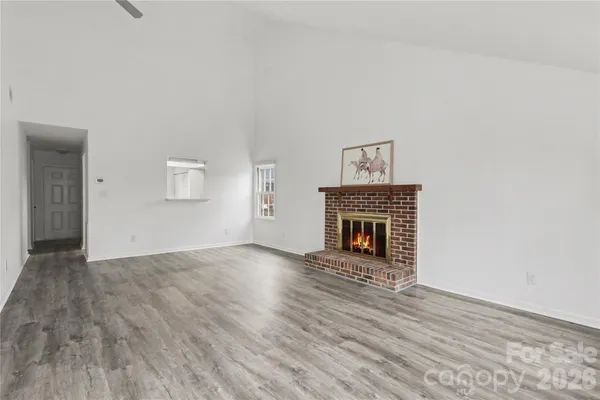 a view of a livingroom with wooden floor and a fireplace