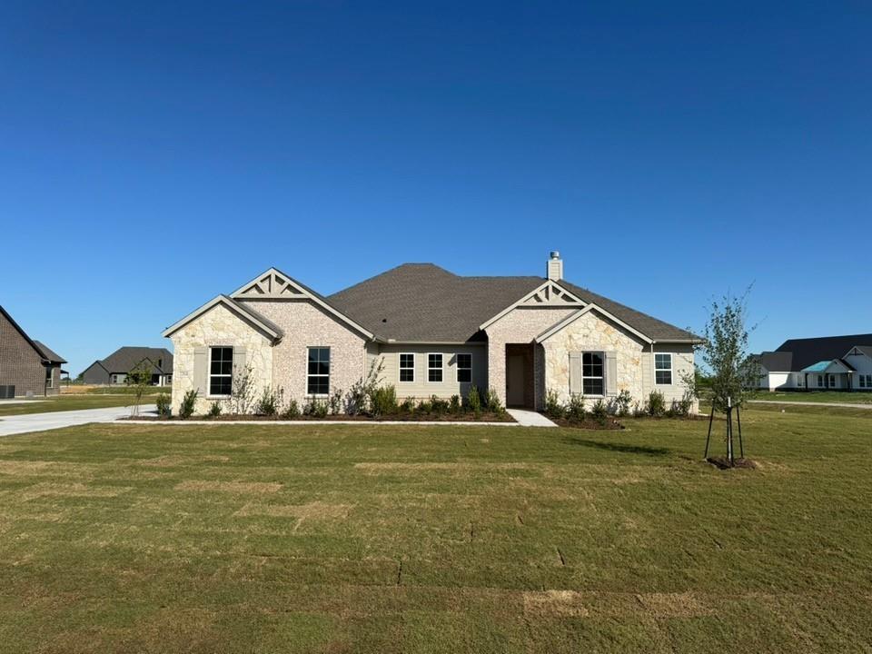 a white house with a big yard and large trees