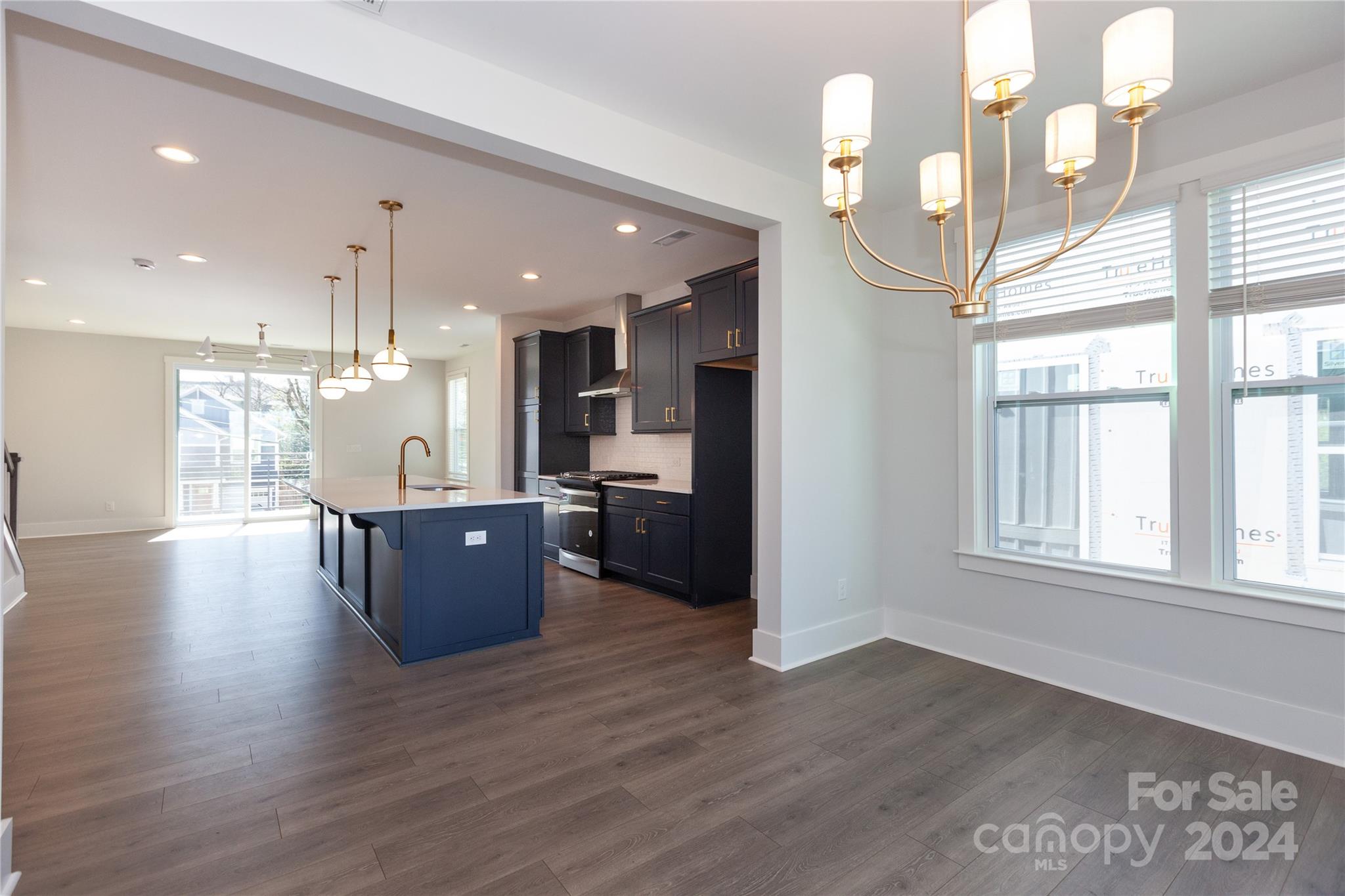 1405 Seigle Avenue Charlotte, NC 28205 - Photo 7 of 35 a large kitchen with stainless steel appliances kitchen island a large counter top and a wooden floors