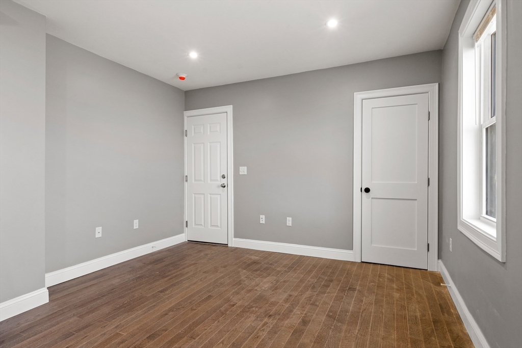 17-19 Spring Garden Street Boston, MA 02125 - Photo 12 of 24 wooden floor in an empty room with a window
