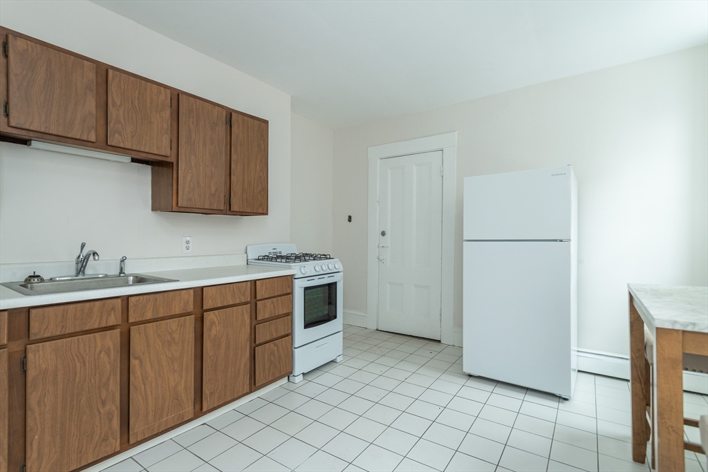 17-19 Spring Garden Street Boston, MA 02125 - Photo 21 of 24 a kitchen with a sink cabinets and appliances