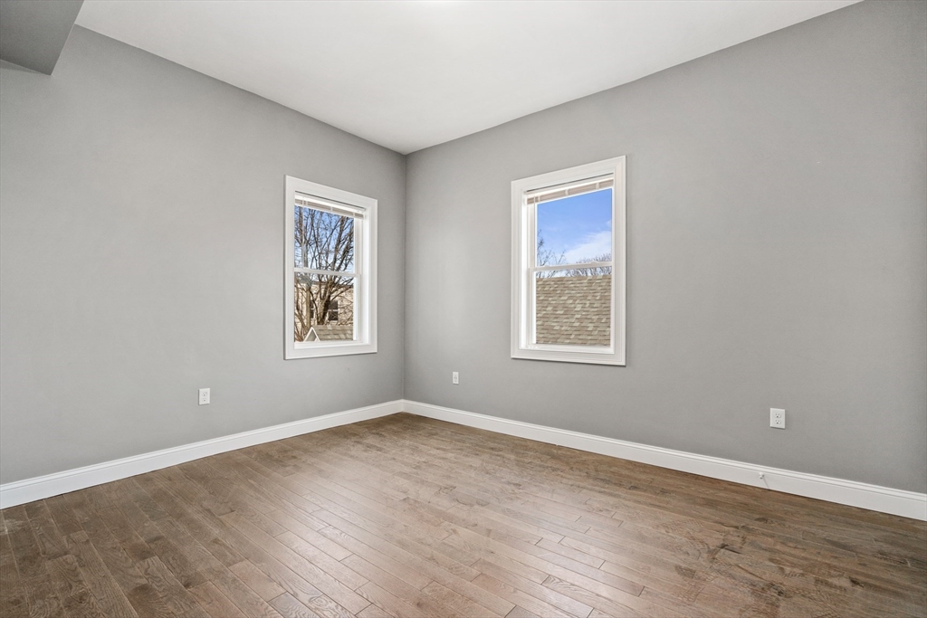 17-19 Spring Garden Street Boston, MA 02125 - Photo 3 of 24 a view of an empty room with wooden floor and a window
