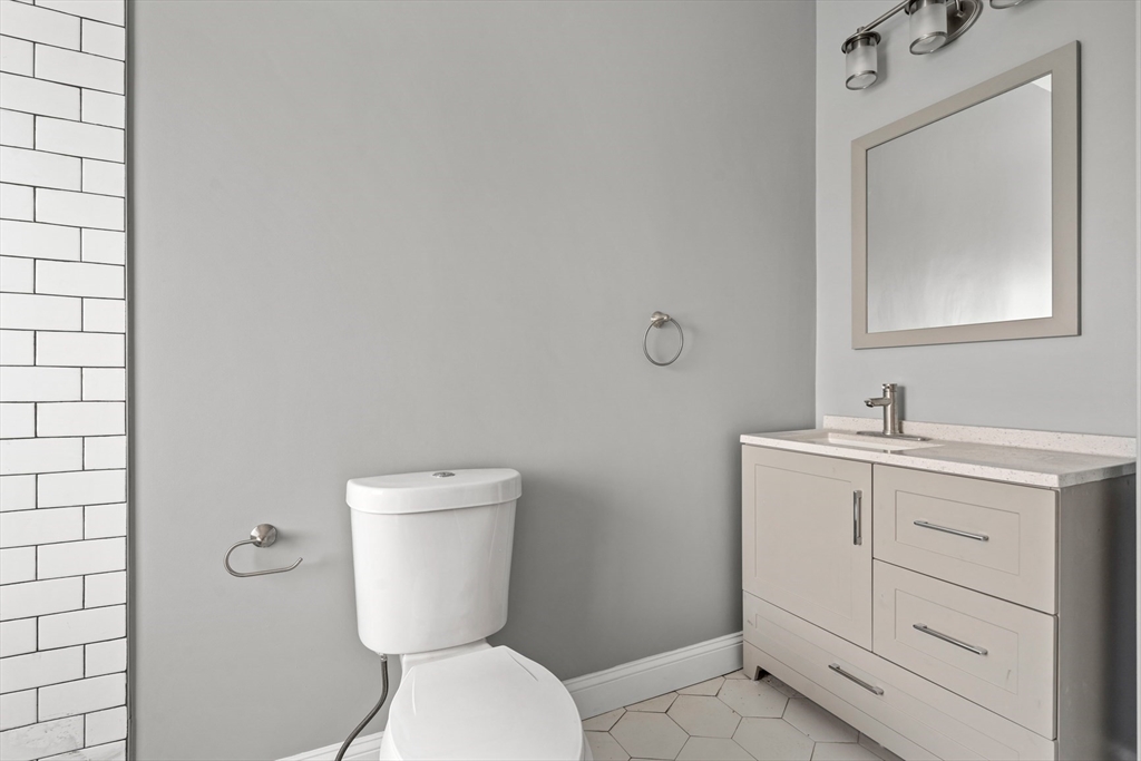17-19 Spring Garden Street Boston, MA 02125 - Photo 8 of 24 a bathroom with a toilet sink and mirror