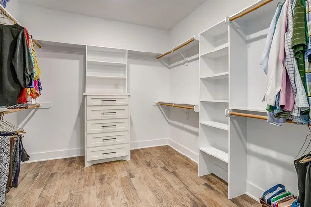 a view of walk in closet with clothes and shoes