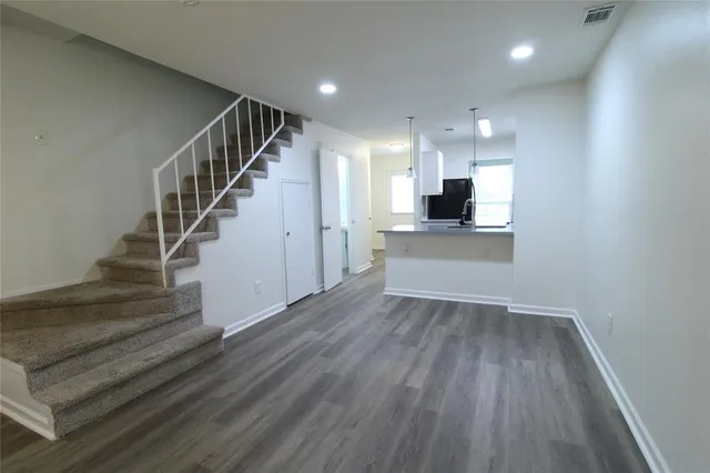 a view of a kitchen with wooden floor and a sink