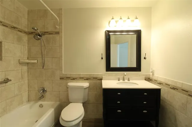 a bathroom with a sink vanity mirror and toilet