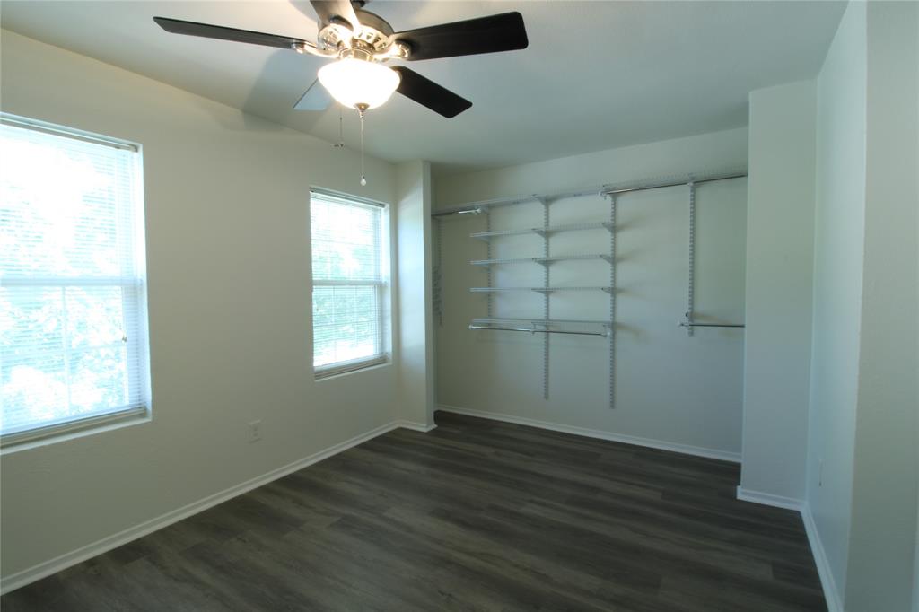 605 Carriagehouse Lane, Unit B2 Garland, TX 75040 - Photo 10 of 11 a view of an empty room with wooden floor and a window