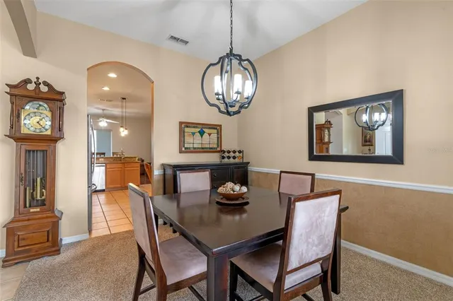 a view of a dining room with furniture a chandelier and wooden floor