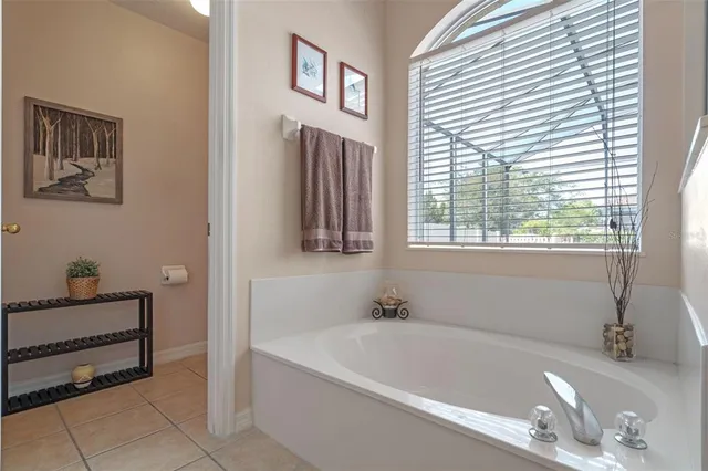 a white bath tub sitting in a bathroom next to a window