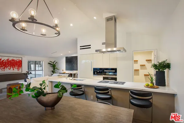 a kitchen with stainless steel appliances kitchen island granite countertop a table chairs a sink and a stove