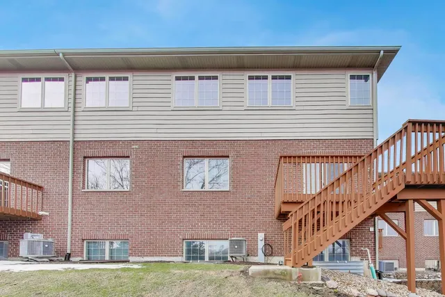 a view of a house with wooden stairs and a small yard