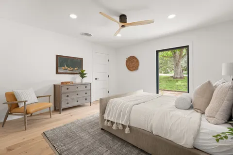 a bedroom with a bed and furniture with window