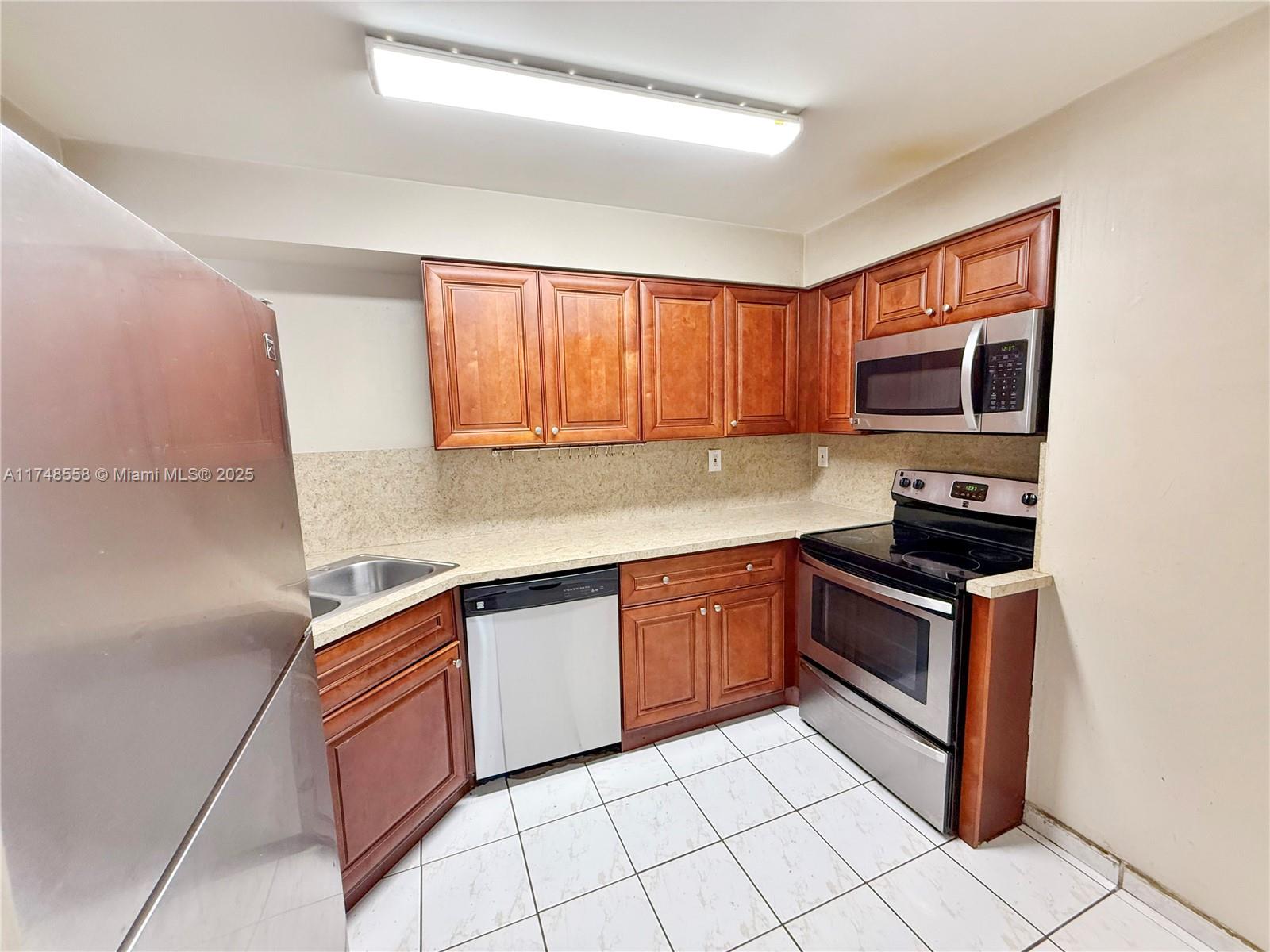 Tamiami Miami, FL 33184 - Photo 11 of 27 a kitchen with stainless steel appliances granite countertop a stove top oven a sink dishwasher and granite counter top