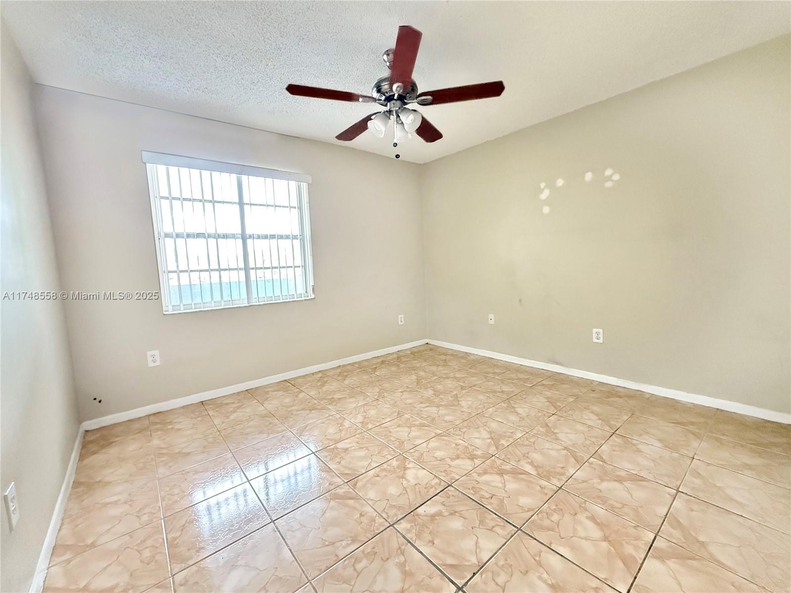 Tamiami Miami, FL 33184 - Photo 12 of 27 a view of a livingroom with a ceiling fan and window