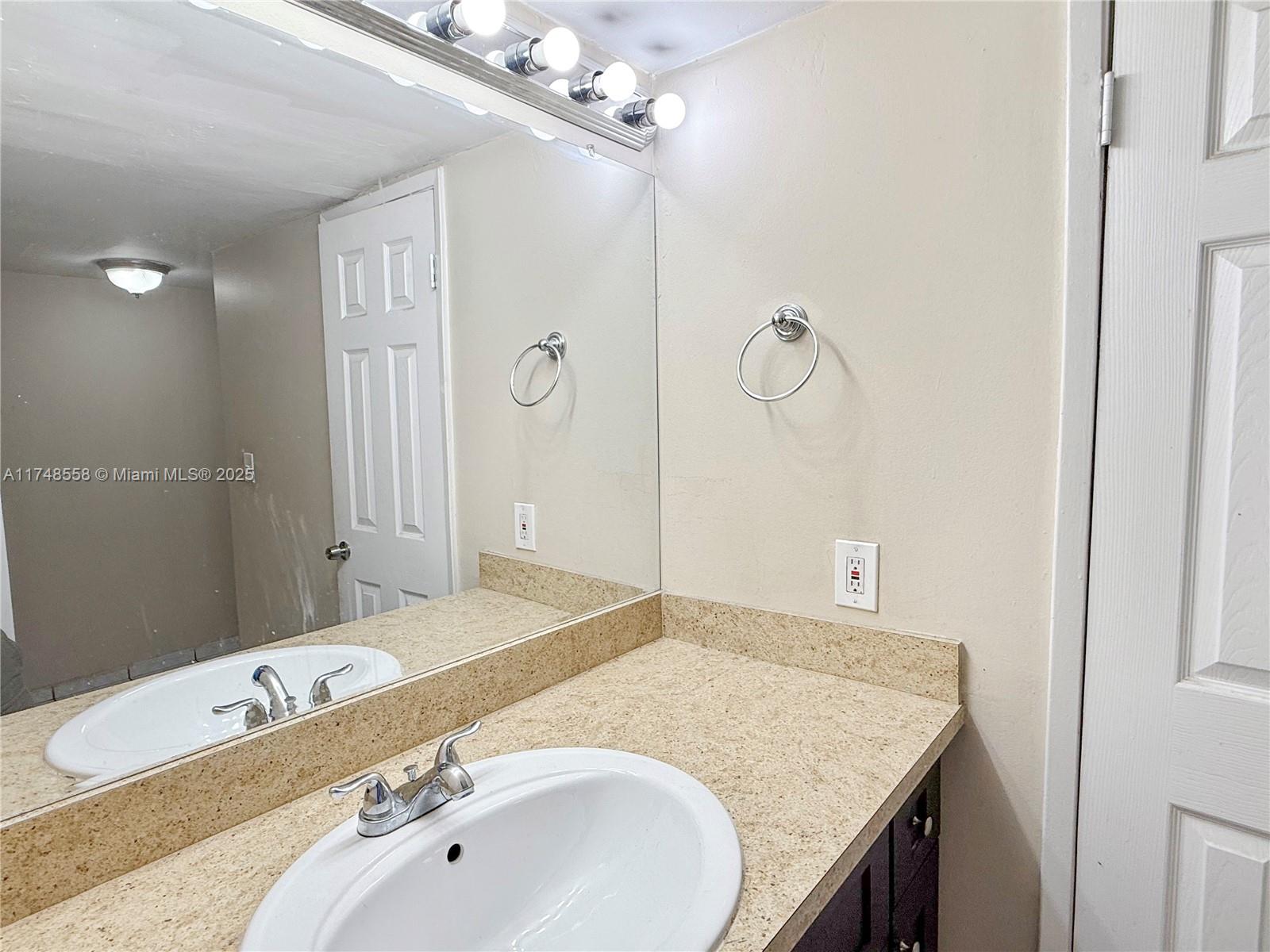 Tamiami Miami, FL 33184 - Photo 15 of 27 a bathroom with a granite countertop sink a mirror and shower