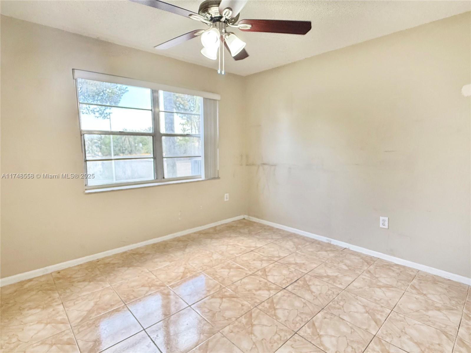 Tamiami Miami, FL 33184 - Photo 27 of 27 an empty room with chandelier fan and windows