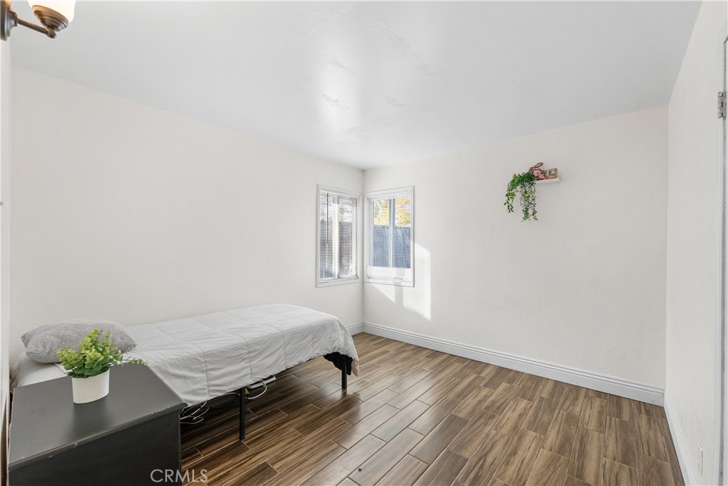 45323 Andale Avenue Lancaster, CA 93535 - Photo 20 of 29 a bedroom with a bed and wooden floor