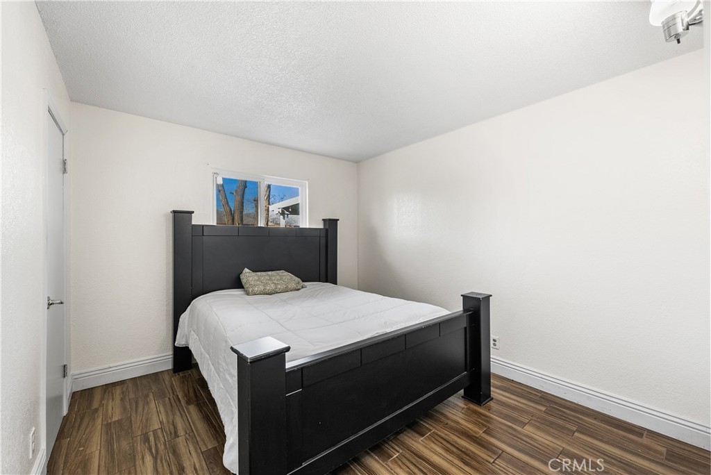 45323 Andale Avenue Lancaster, CA 93535 - Photo 23 of 29 a bedroom with a bed and wooden floor