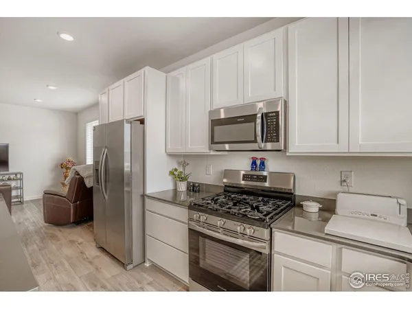 a kitchen with stainless steel appliances kitchen island granite countertop a table chairs microwave and sink