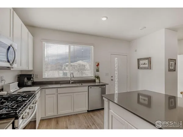 a kitchen with stainless steel appliances granite countertop a refrigerator stove and microwave