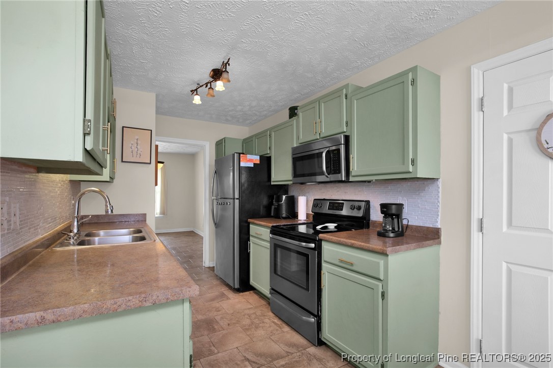 5004 Paulsun Drive Fayetteville, NC 28304 - Photo 12 of 31 a kitchen with stainless steel appliances granite countertop a sink dishwasher stove top oven and refrigerator with wooden cabinets