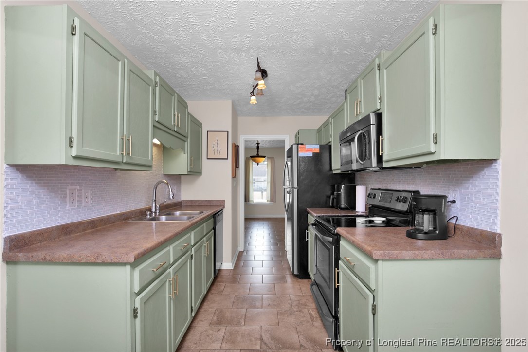 5004 Paulsun Drive Fayetteville, NC 28304 - Photo 13 of 31 a kitchen with stainless steel appliances granite countertop a sink stove and refrigerator