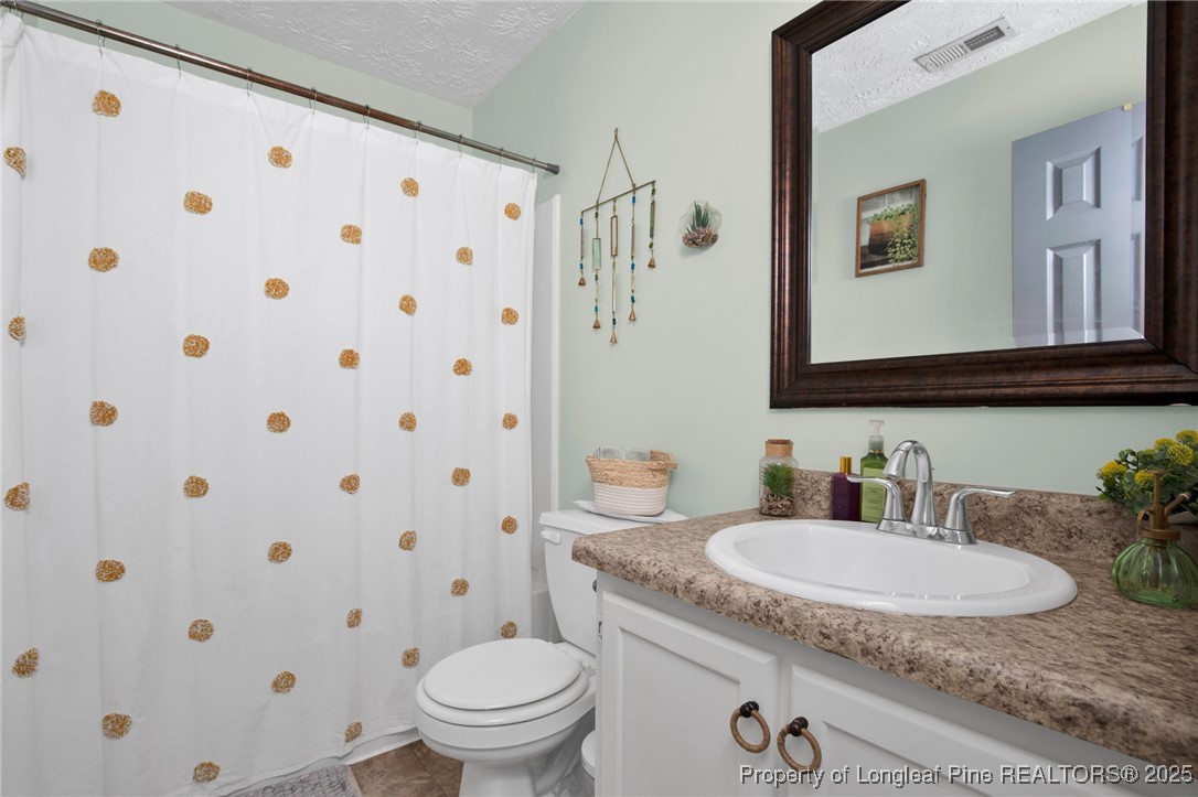 5004 Paulsun Drive Fayetteville, NC 28304 - Photo 19 of 31 a bathroom with a granite countertop sink and a mirror