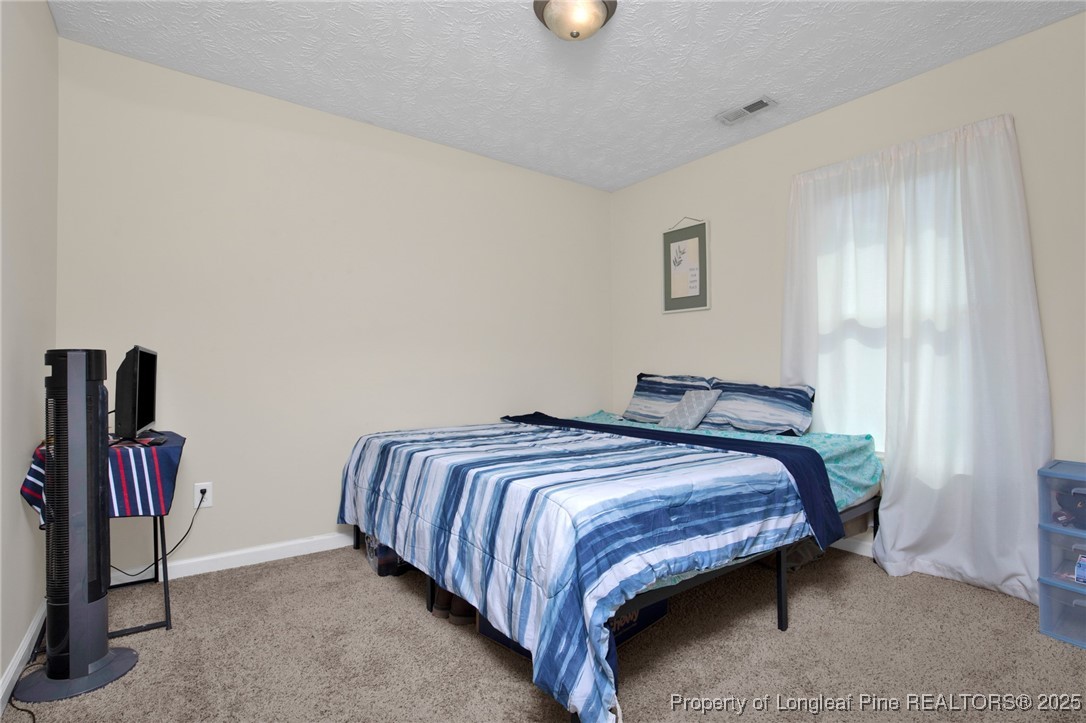 5004 Paulsun Drive Fayetteville, NC 28304 - Photo 20 of 31 a bedroom with bed and night stand