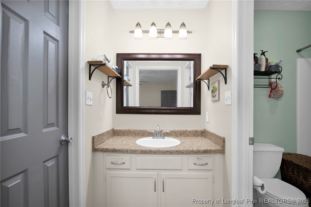 5004 Paulsun Drive Fayetteville, NC 28304 - Photo 24 of 31 a bathroom with a granite countertop sink and a mirror