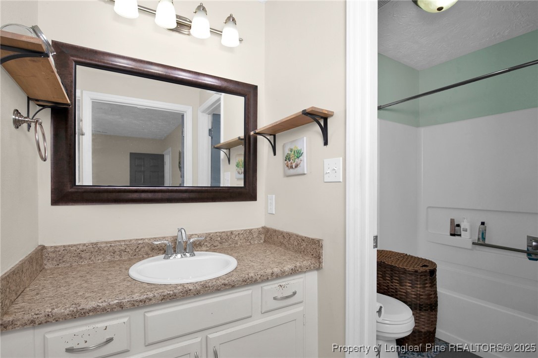 5004 Paulsun Drive Fayetteville, NC 28304 - Photo 25 of 31 a bathroom with a granite countertop sink vanity and mirror