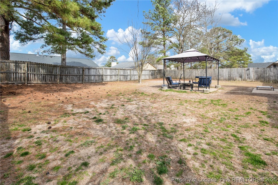 5004 Paulsun Drive Fayetteville, NC 28304 - Photo 31 of 31 a view of a yard with table and chairs under an umbrella