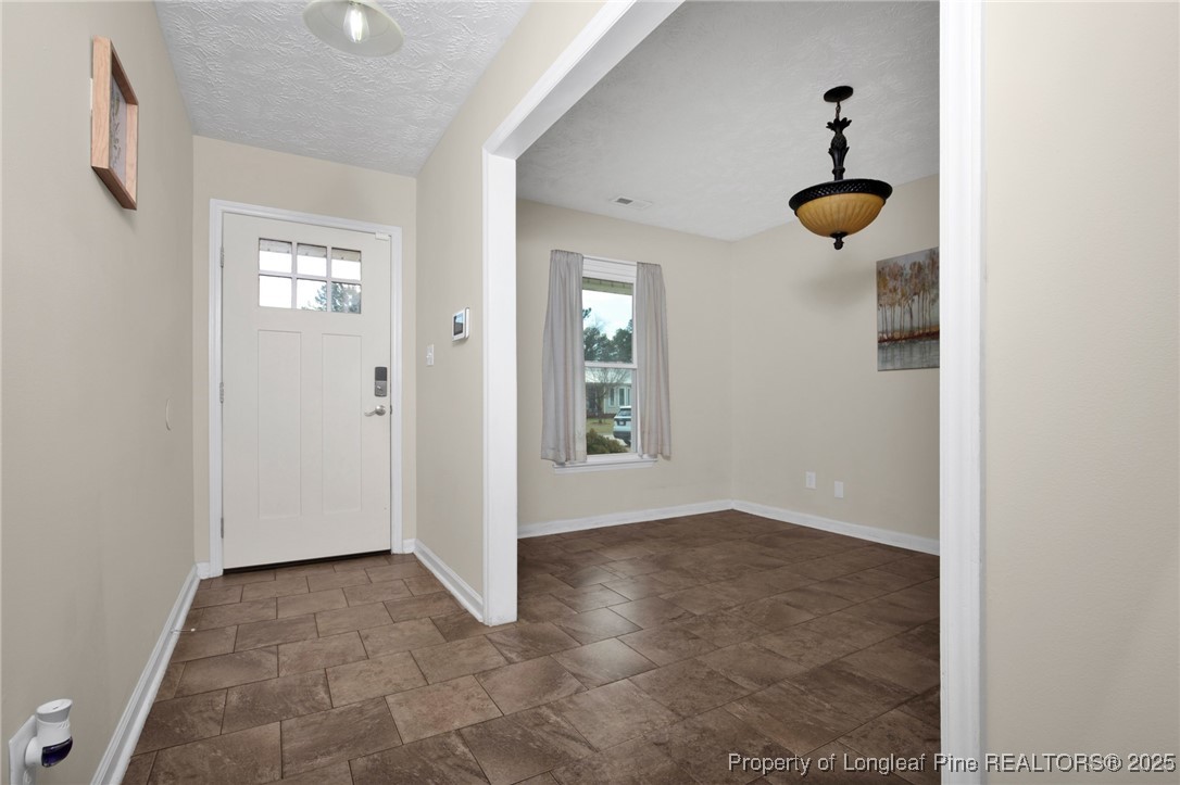 5004 Paulsun Drive Fayetteville, NC 28304 - Photo 5 of 31 an empty room with windows and chandelier