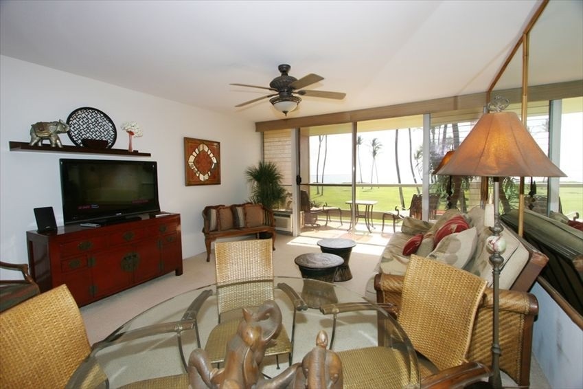 998 South Kihei Road, Unit 205 Kihei, HI 96753 - Photo 3 of 12 a living room with furniture a flat screen tv and a large window