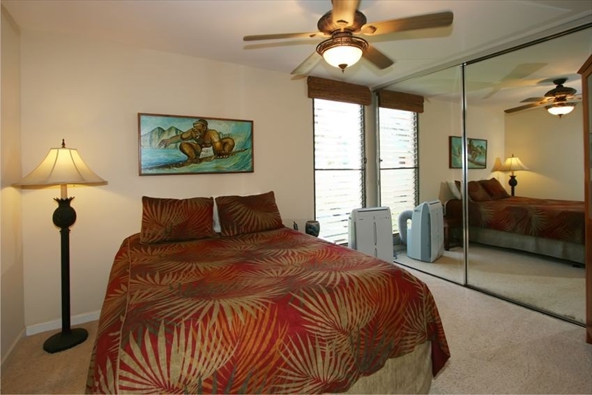 998 South Kihei Road, Unit 205 Kihei, HI 96753 - Photo 5 of 12 a bedroom with a bed and a chandelier