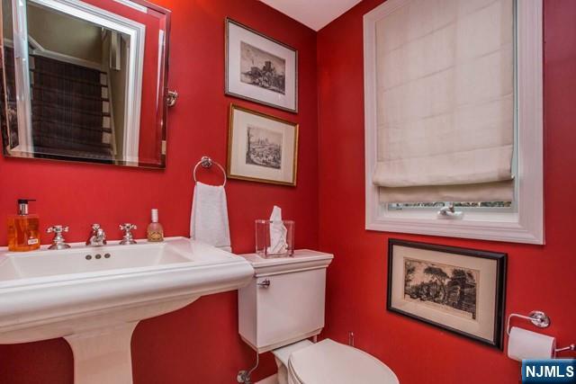 10 Orchard Place Tenafly, NJ 07670 - Photo 11 of 25 a bathroom with a toilet a sink and mirror