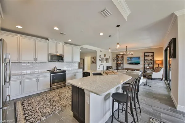 a kitchen with stainless steel appliances granite countertop a stove top oven a sink refrigerator and cabinets