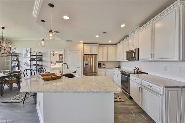 a kitchen with stainless steel appliances kitchen island granite countertop a sink and cabinets