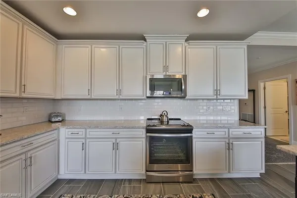 a kitchen with white cabinets appliances and sink