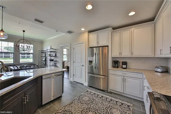 a kitchen with white cabinets and stainless steel appliances