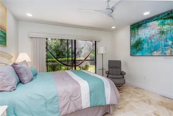 a bedroom with a bed and a large mirror next to a window
