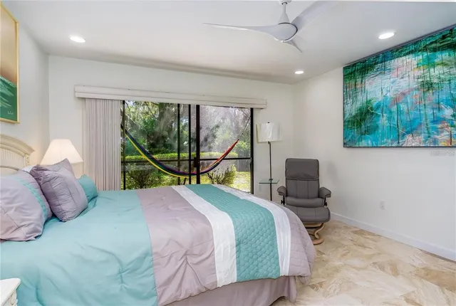 a bedroom with a bed and a large mirror next to a window