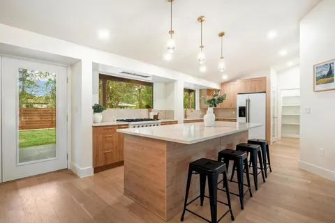 a large kitchen with kitchen island a large island in it