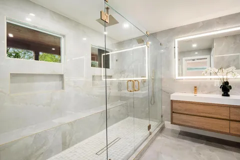 a bathroom with a tub sink shower and mirror