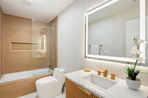 a bathroom with a granite countertop sink a toilet and a bathtub