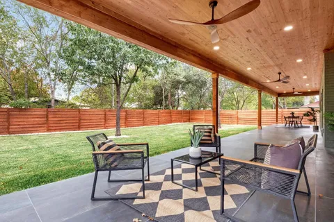 a view of a patio with table and chairs and floor to ceiling window